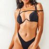 Model wearing a chic black straps bikini and a stylish cut out one piece swimsuit from Zipporaa