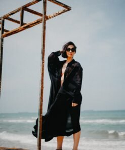 Model wearing a flowy black maxi kaftan on the beach