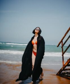 A girl at beach wear black kaftan and orange bikini looking beautiful in swimwear dress